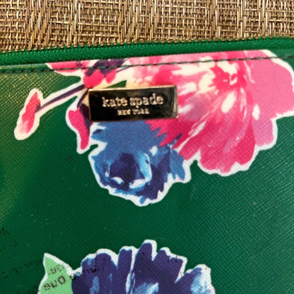 Kaye Spade floral wristlet, has a small area with something on it .